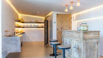 A modern kitchen with a central island, bar stools, and pendant lighting.