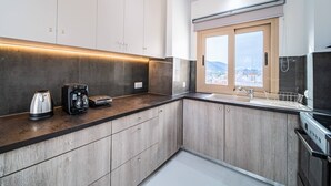 A modern kitchen with a built-in oven, a coffee maker, and a kettle on the counter.