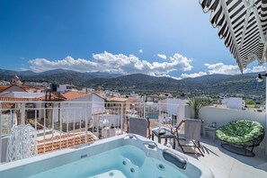 A rooftop terrace with a hot tub, outdoor seating, and a view of the city and mountains. - Napoleon Navy Suite 1bd 1ba (Malia)