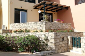 A stone-built structure with a covered patio, potted plants, and a stone wall. - Nina's Place, 5min On Foot From The Beach (Panormos)