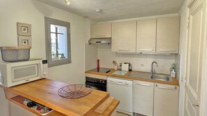 A compact kitchen with a microwave, stove, dishwasher, and wooden countertop. - Apartment T2 - 3 people - Air conditioning - Pool and tennis residence - Unobstructed view -... (STE MAXIME)