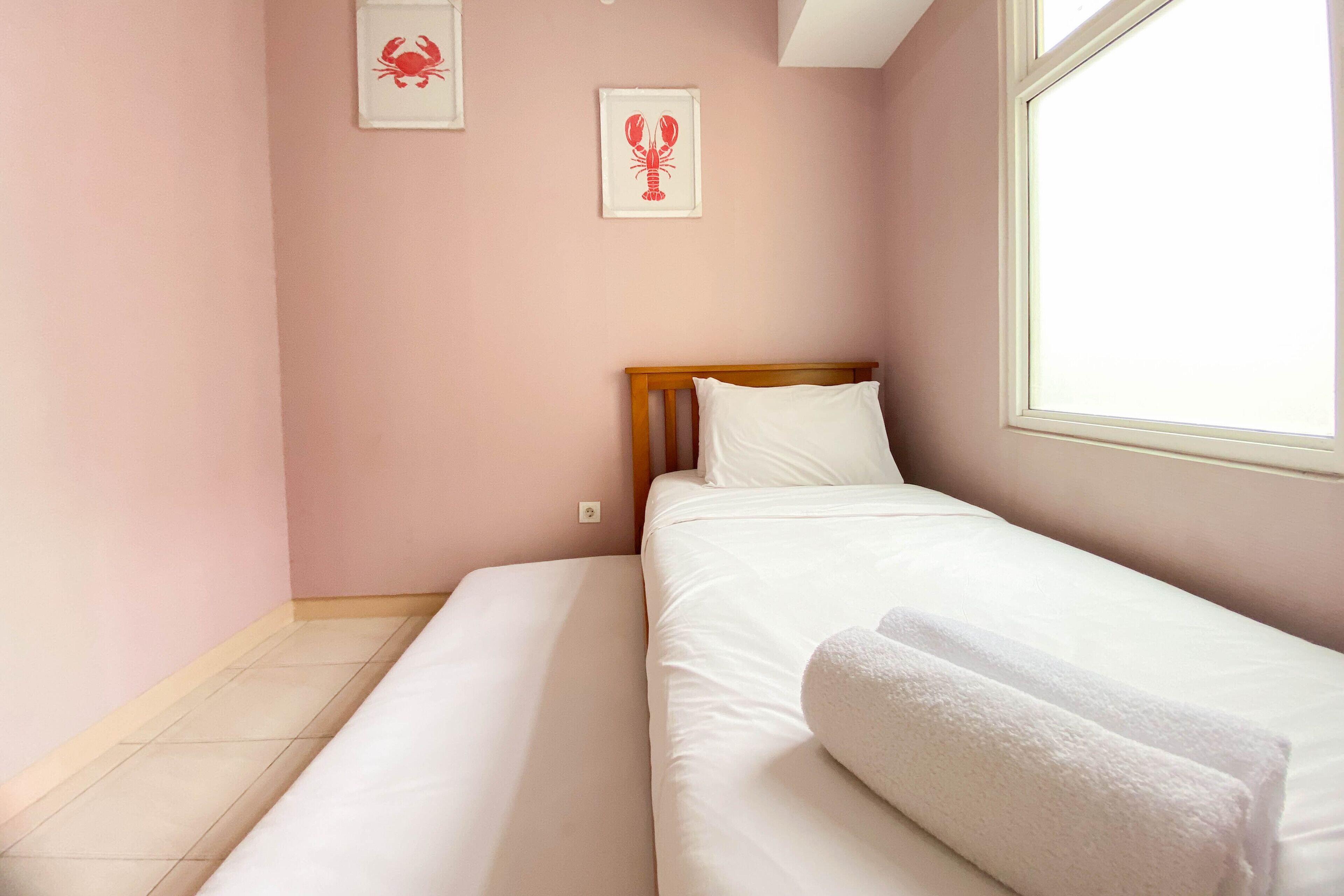 A bedroom with a single bed, a wooden headboard, and a window.