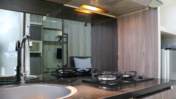 A kitchen with a sink, stove, and cabinets.