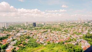 A cityscape with a mix of residential and commercial buildings, a clear sky, and scattered clouds. - Homey And Simply Look 1Br Bintaro Embarcadero Apartment (South Tangerang)