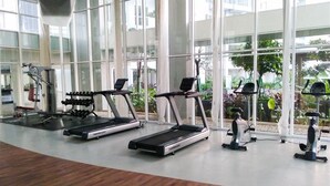 A gym with treadmills, dumbbells, and exercise machines. - Homey And Best Deal 1Br Casa De Parco Apartment (Pagedangan)