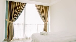 A hotel room with a large bed, curtains, and a view of the outside. - Spacious And Elegant 2Br At 35Th Floor Hillcrest House Apartment (Curug)