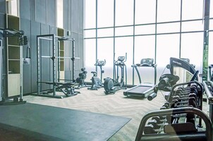 Un gimnasio con diferentes equipos de ejercicio, como cintas de correr, mancuernas y máquinas de pesas.