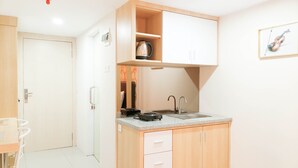 A compact kitchen with a countertop, sink, and wooden cabinets.