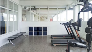 A gym with treadmills, weight machines, and a bench.