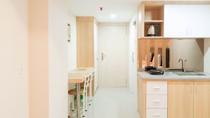 A compact kitchen with a countertop, sink, and wooden cabinets.