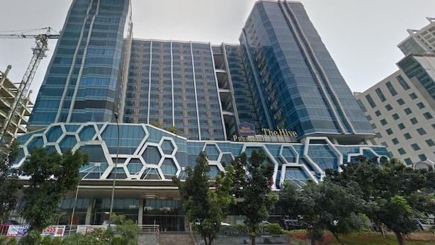 A modern hotel with a distinctive geometric facade and multiple high-rise buildings in the background.