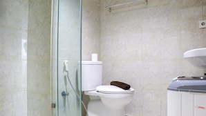 A bathroom with a glass-enclosed shower, a toilet, and a sink.