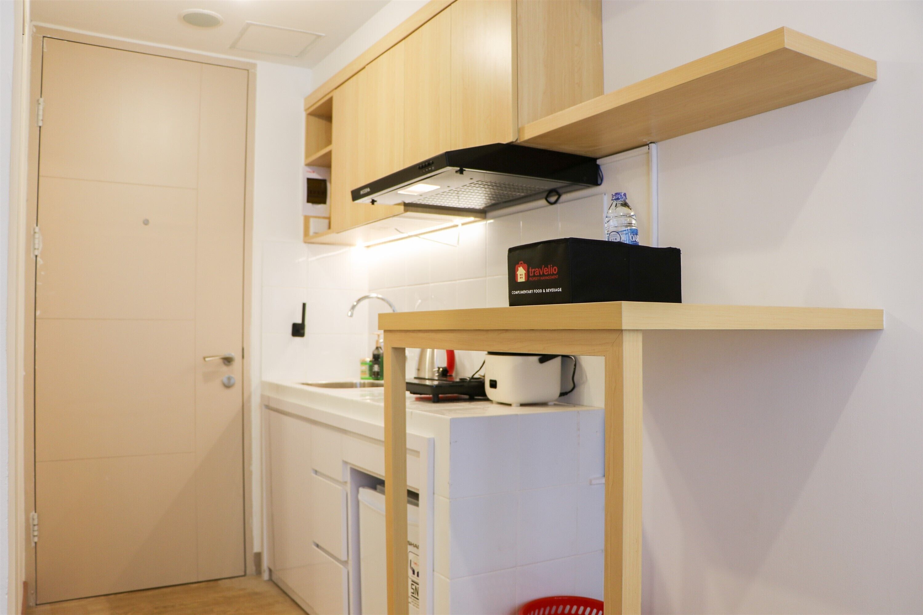 A compact kitchen with wooden cabinets, a built-in stove, and a small refrigerator.