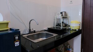 A compact kitchen with a stainless steel sink, a coffee maker, and a small refrigerator. - Homey Studio Room At 7Th Floor Gateway Pasteur Apartment (Cimahi)
