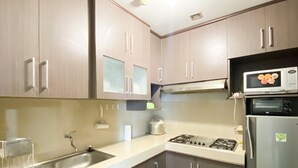 Una cocina con electrodomésticos de acero inoxidable, un lavamanos y armarios de madera.