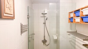 Enjoy a refreshing shower experience with a handheld showerhead and convenient storage for your essentials.
