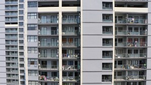 A multi-story residential building with balconies, air conditioning units, and laundry hanging on some balconies. - Brand New 2BR at Daan Mogot City Apartment By Travelio (Jakarta)