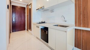Una cucina moderna con mobili bianchi, lavastoviglie integrata e lavello in acciaio inossidabile.
