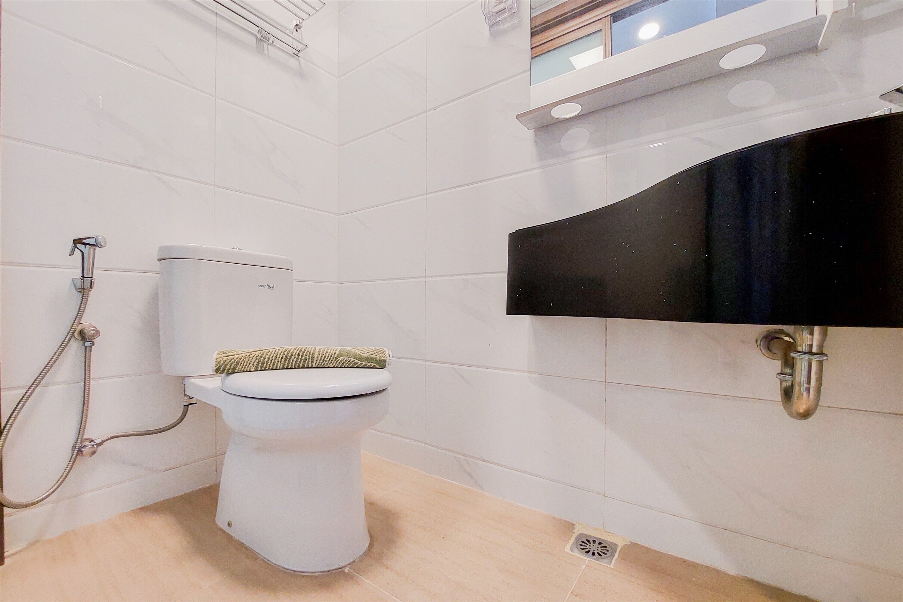 A modern bathroom with a toilet, shower, and sink.