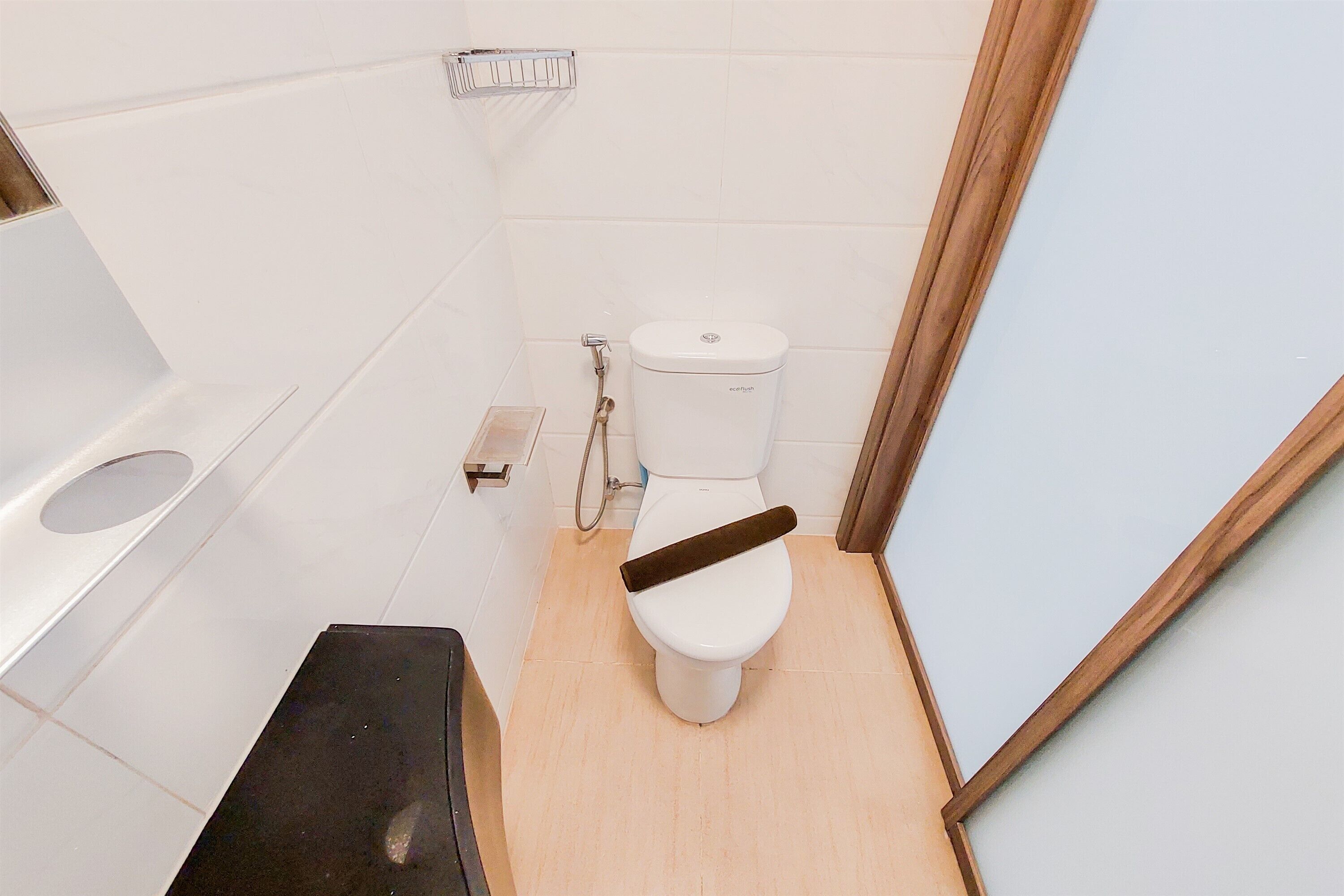 A small, clean bathroom with a white toilet, a shower, and a sink.