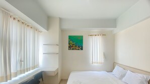 A hotel room with a bed, a desk, and a chair. - Homey And Cozy Stay Studio Margonda Residence 3 Apartment (Depok)