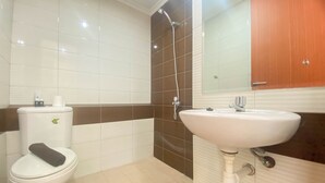 A bathroom with a toilet, sink, and shower. - Homey And Cozy Stay Studio Margonda Residence 3 Apartment (Depok)