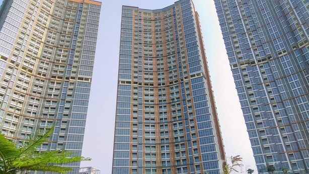 Tres edificios de gran altura con un diseño arquitectónico moderno, que presenta una cuadrícula de ventanas y una fachada curva.