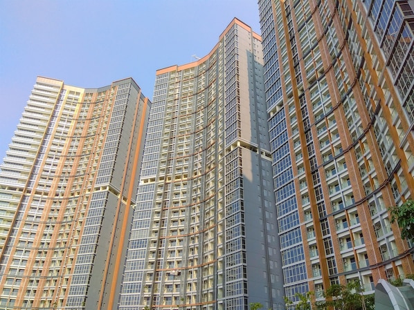 A high-rise residential building with multiple floors, large windows, and a modern architectural design.