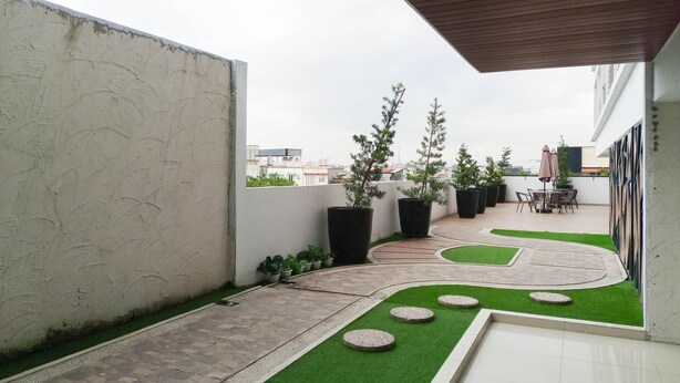 A rooftop garden with potted plants, a patio area, and a view of the cityscape.