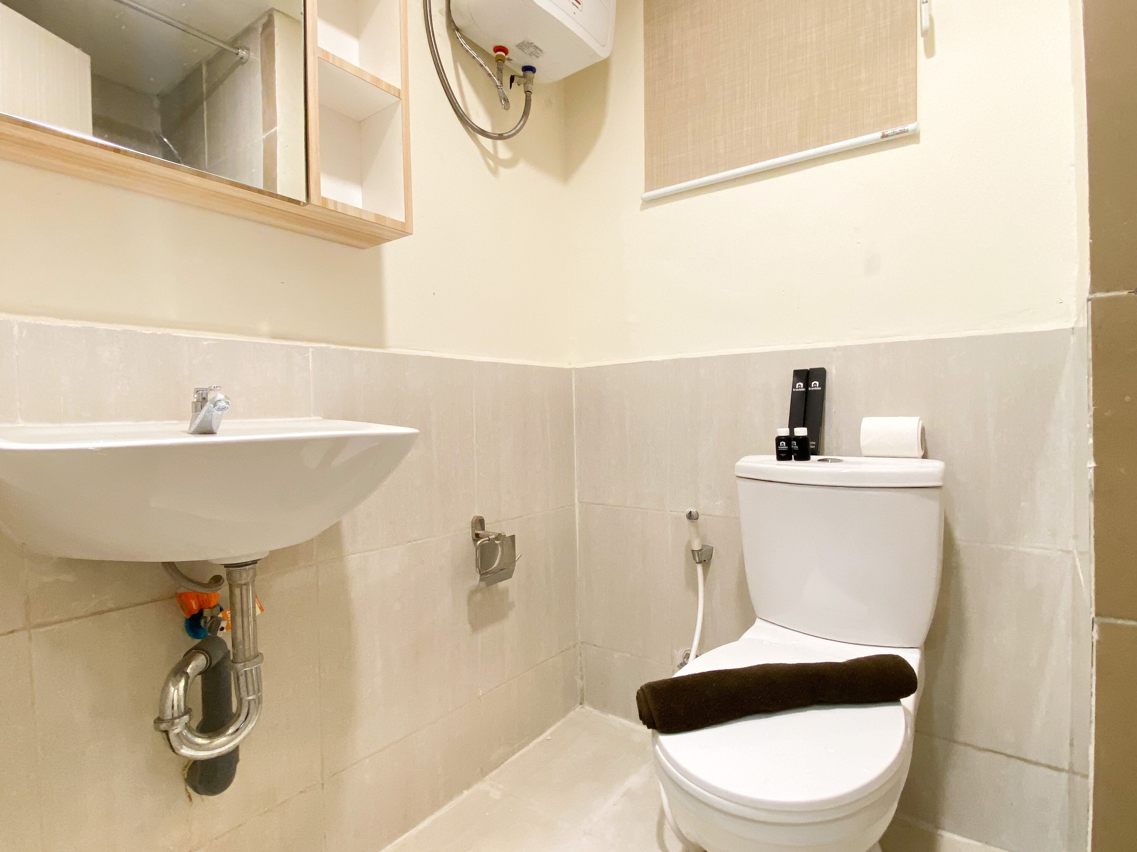 A bathroom with a sink, toilet, and a mirror.