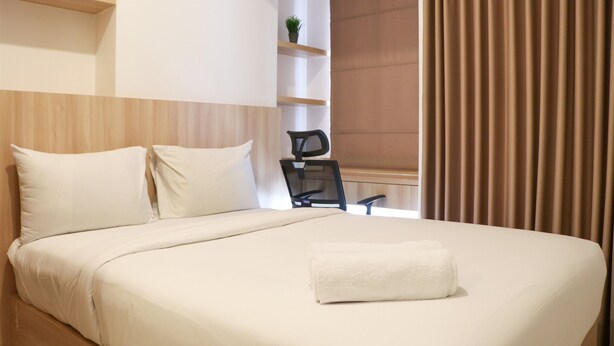 A hotel room with a bed, a chair, a desk, and a window with curtains. - Relaxing Studio Apartment At Tokyo Riverside Pik 2 (Teluknaga)