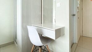 A modern bathroom with a white vanity, a mirror, and a white chair. - Restful And Simply Studio Springlake Summarecon Bekasi Apartment (Bekasi)