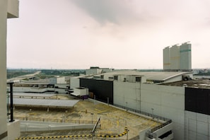 A view of a large industrial building with multiple levels and a parking area. - Comfort And Modern Look 3Br Sky House Bsd Apartment (Pagedangan)