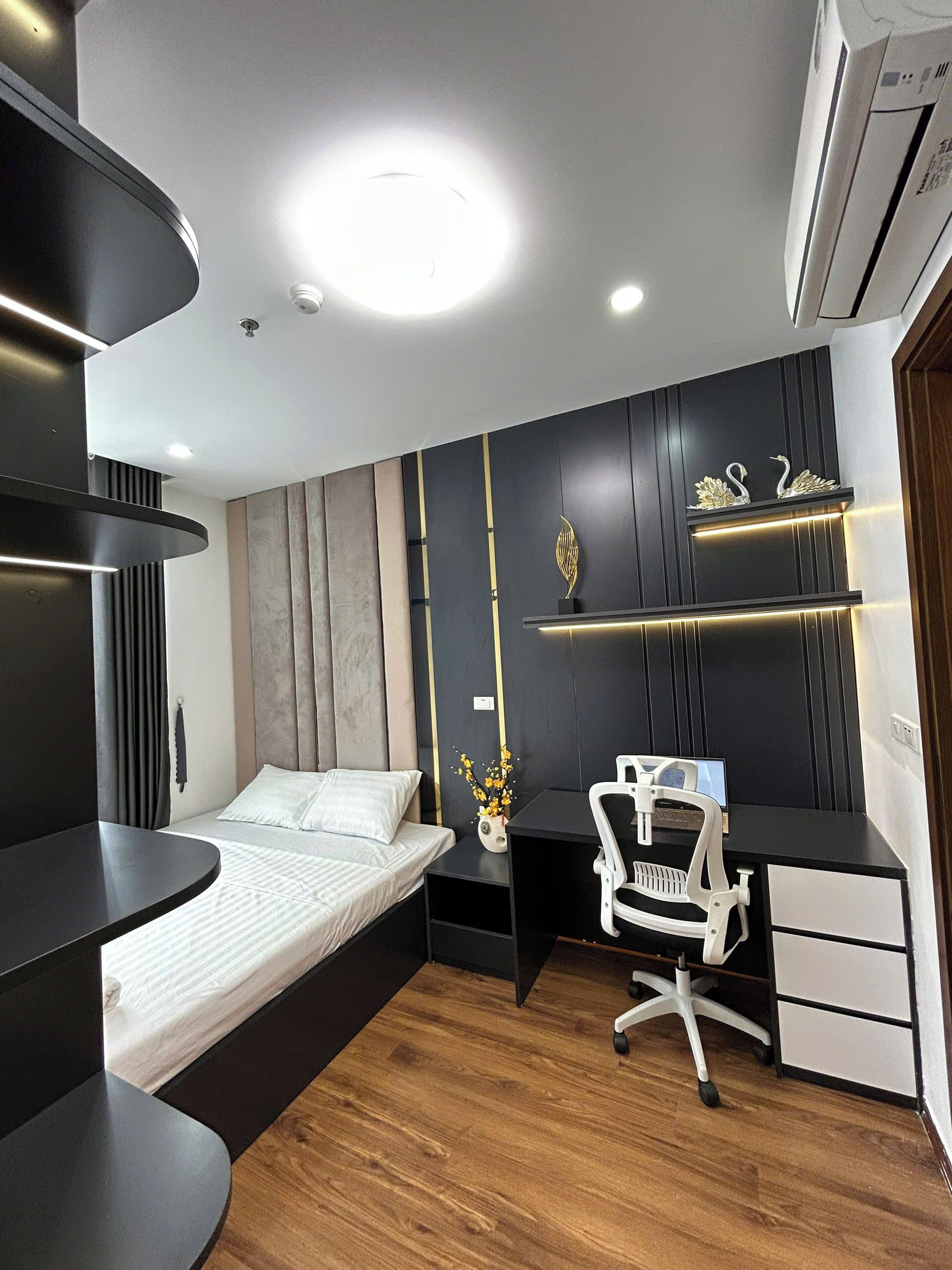 A modern bedroom with a bed, a desk, and a chair.
