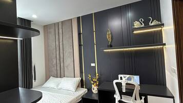 A modern bedroom with a bed, a desk, and a chair.
