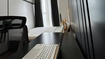 A modern hotel room with a desk, a bed, and a large mirror.