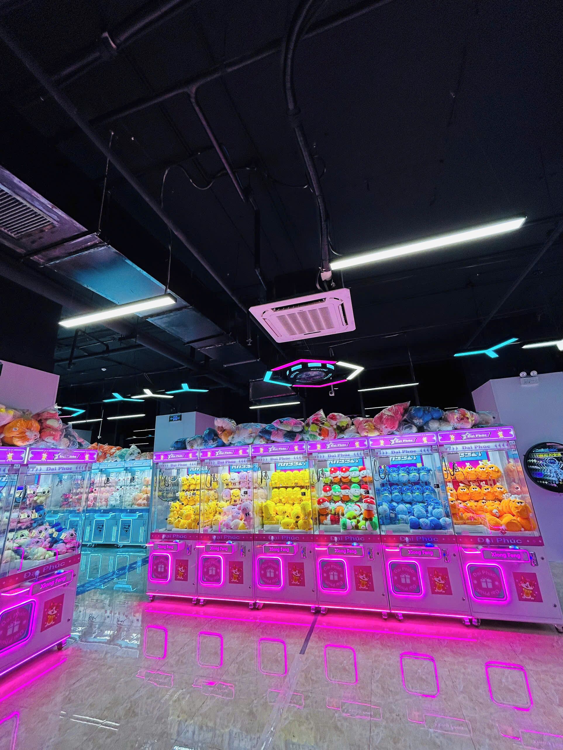 A brightly lit arcade area with claw machines filled with plush toys.