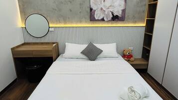 A modern bedroom with a large bed, a bedside table, a mirror, a teddy bear, and a wall-mounted shelf.