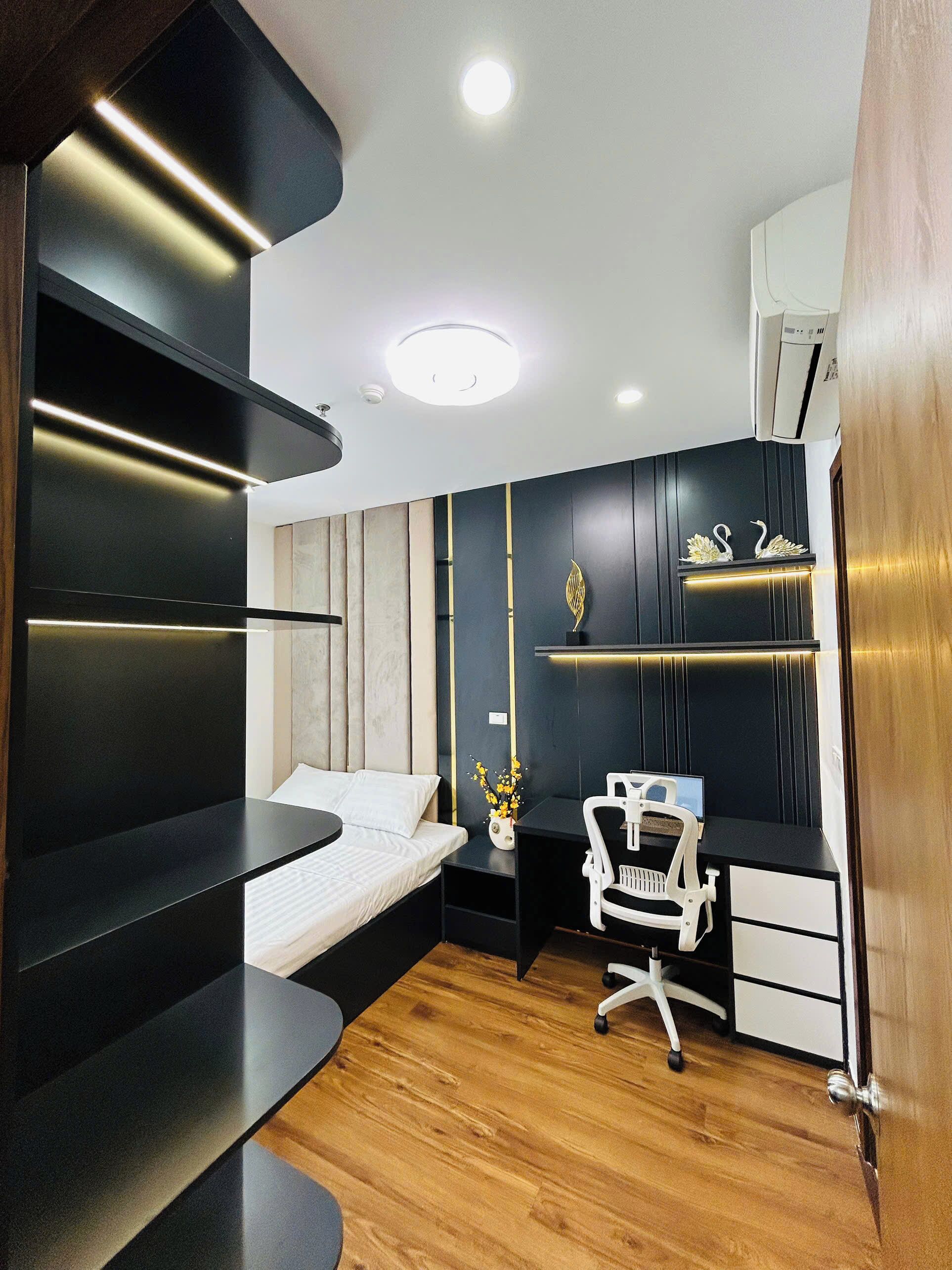 Ein modernes Schlafzimmer mit Bett, Nachttisch, Schreibtisch, Stuhl und Dekorationselementen.