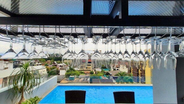 A rooftop pool area with a view of a building in the background. - Ama's House Luxury Boutique Hotel (Chiang Mai)