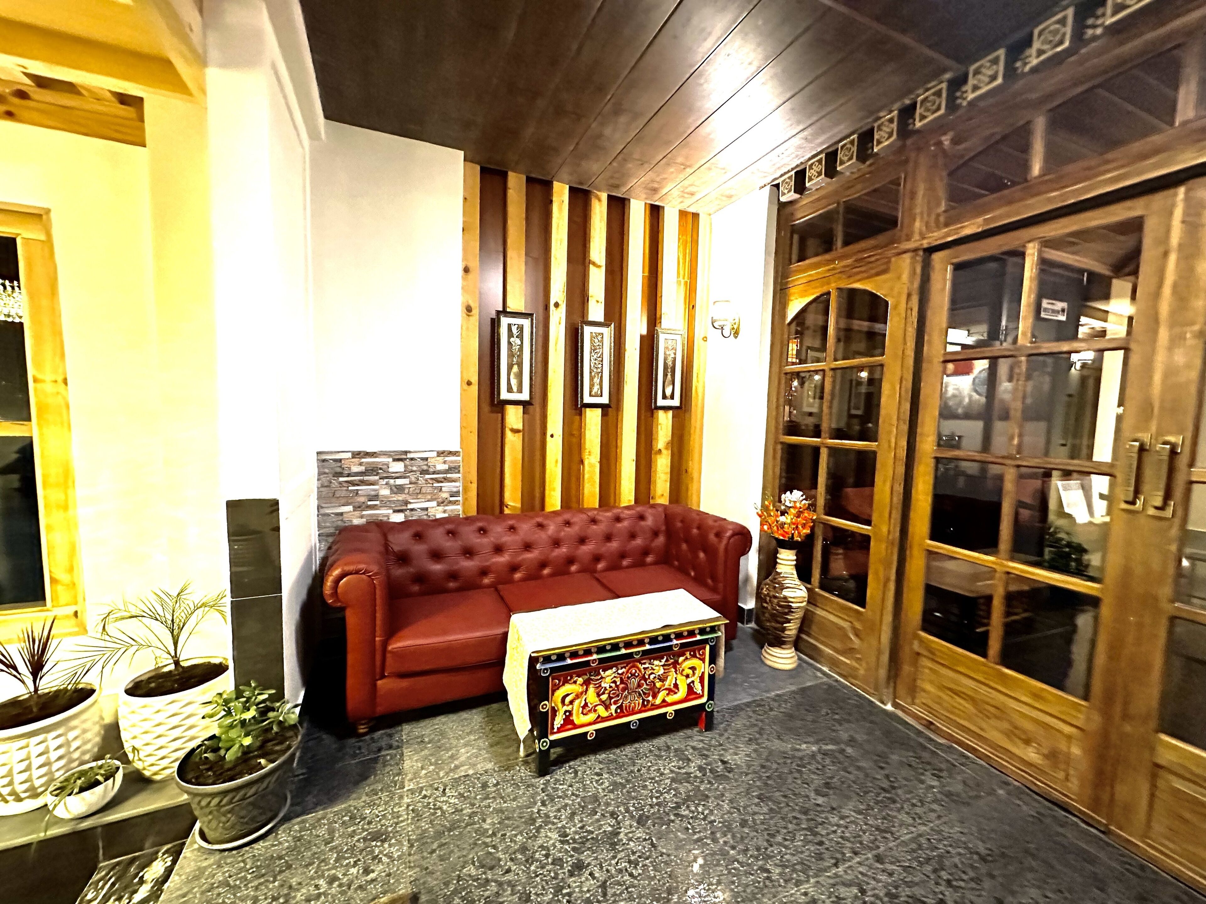 A cozy living room with a red sofa, a small table, and decorative items.