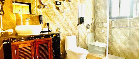 Un baño con encimera de mármol, lavabo, inodoro, cabina de ducha y espejo.
