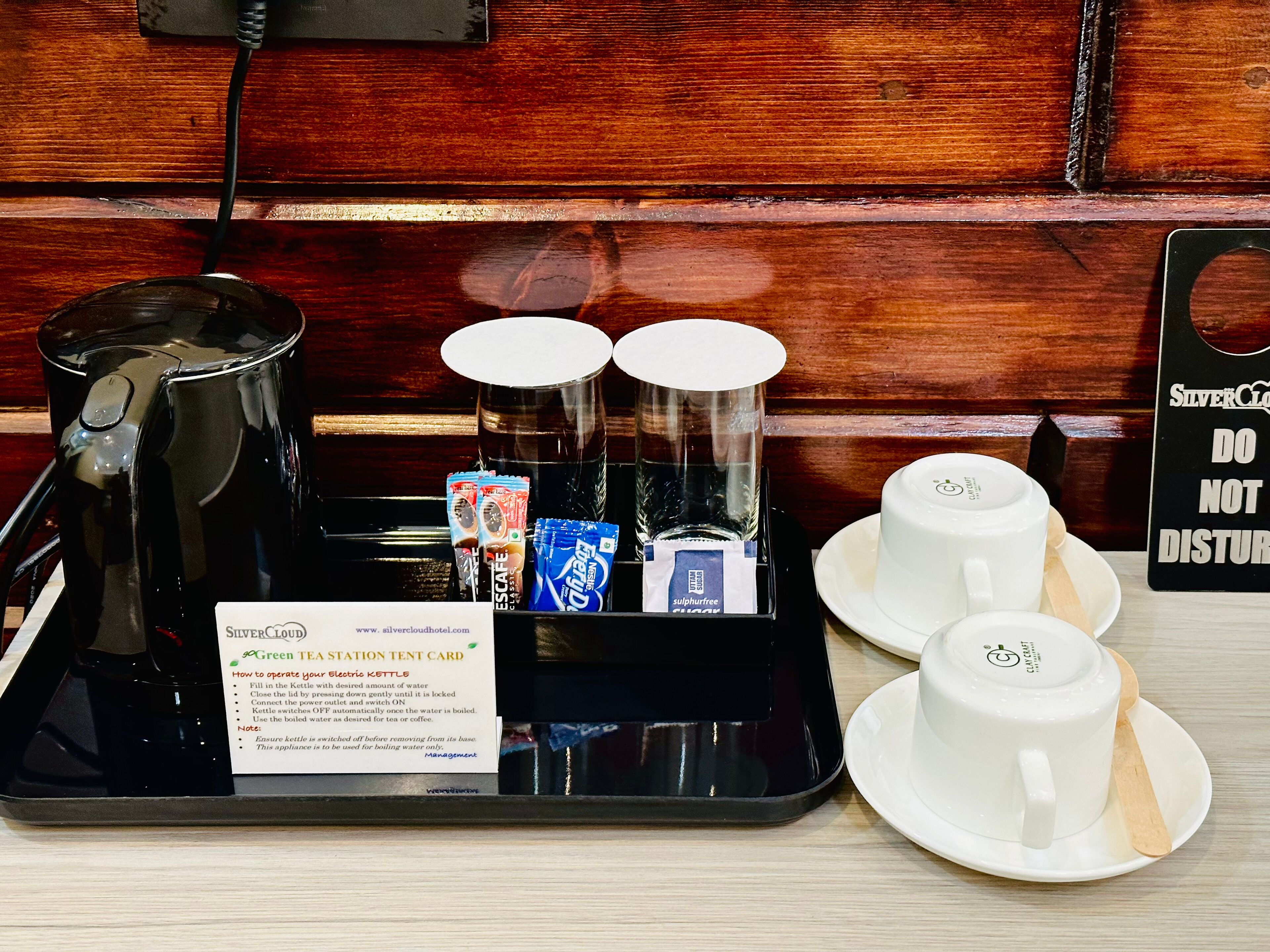 Angolo caffè con bollitore, tazze e bustine di tè.