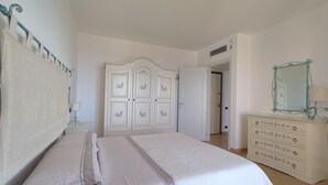 A bedroom with a bed, a wardrobe, a dresser, and a mirror. - Elegant apartment with sea view (Nebida)