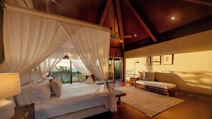 Une chambre à coucher avec un lit à baldaquin, un canapé et une vue sur l’extérieur.