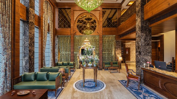 A lobby with a grand chandelier, green sofas, a reception desk, and a decorative centerpiece. - WelcomHeritage Grand Srinagar (Srinagar)
