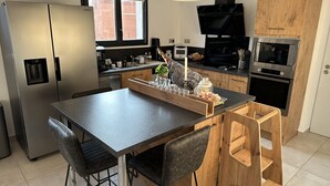 Cocina moderna con una isla central, electrodomésticos de acero inoxidable y armarios de madera.
