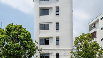 Een modern gebouw met een gebogen gevel, meerdere ramen en een stenen fundering.