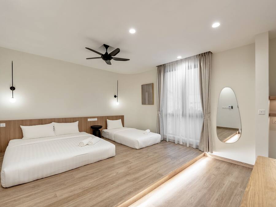 A modern hotel room with two beds, a ceiling fan, recessed lighting, a large mirror, and a wooden floor.