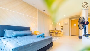 A modern hotel room with a large bed, a dining area, and a fan. - Kuching Riverine Resort  (Kuching)